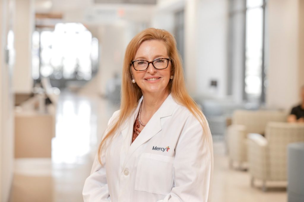 Photo from chest up of Jennifer Bell in a white lab coat
