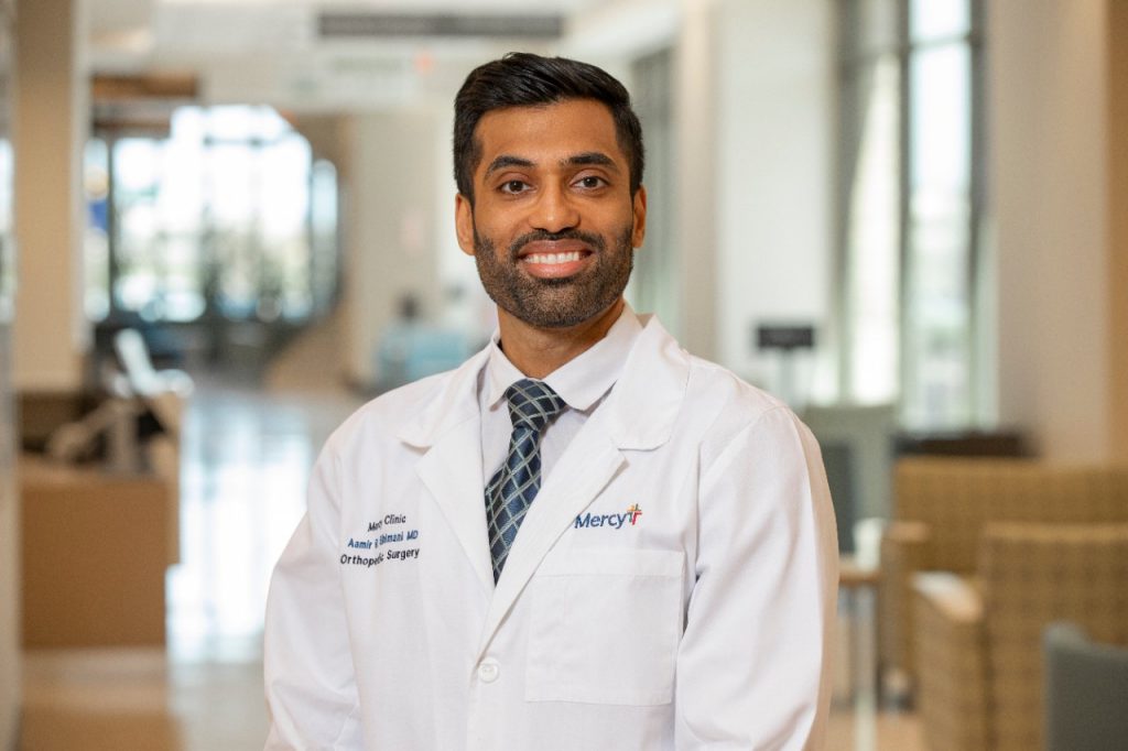 Dr. Aamir Bhimani in a white lab coat