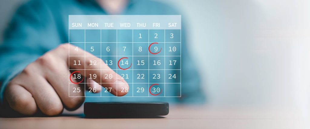 A graphic design of a semi-transparent image of a calendar, with some dates circled, superimposed over a file photo of a person about to press on a smartphone screen.