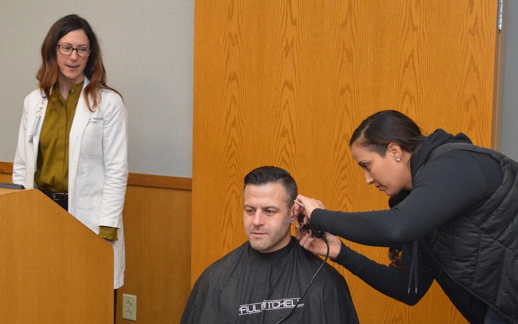 Dr. Patricia Heller watches as a clean shaven Ryan Johnston gets a few finishing touches from stylist Jamie Kasten.