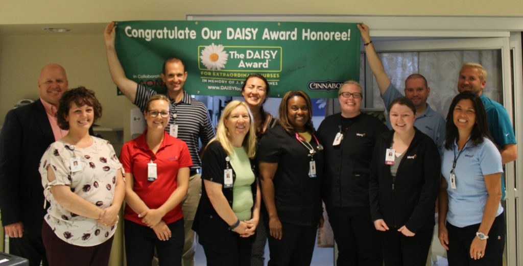 Jackie Gray, RN, ICU, (center) is surrounded by co-workers who presented her with a DAISY Award at Mercy Hospital Lincoln.