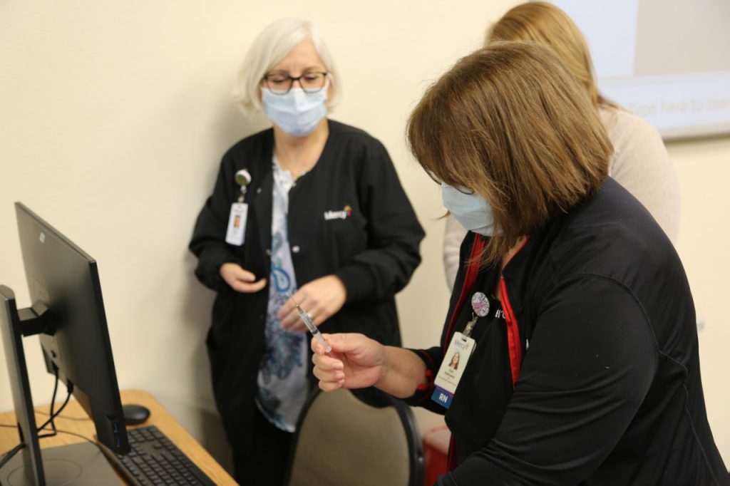 Zoe Hathaway, RN, prepares to administer the COVID-19 vaccine to Dr. Candy Lindsey on Tuesday.