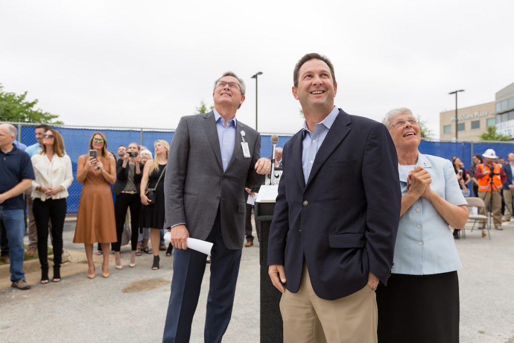 Dr. Steve Goss, president of Mercy Clinic, Eric Pianalto, president of Mercy Hospital, and Sister of Mercy Anita DeSalvo watch as a steel beam signed by co-workers, board and community members is lifted into place. 