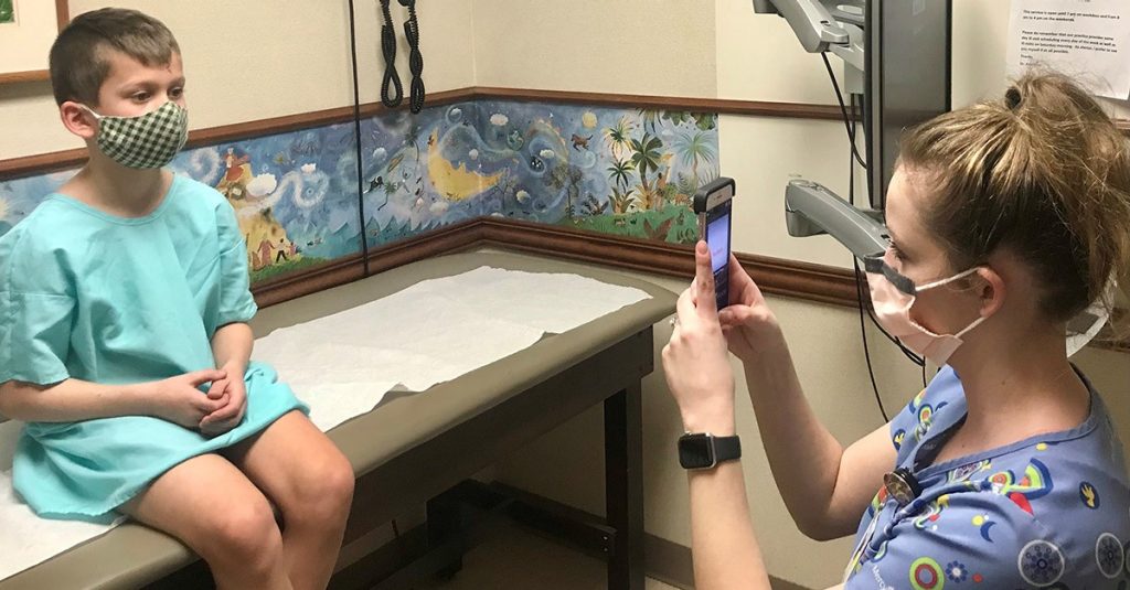 A child gets their eyes checked with a quick picture using the GoCheck Kids software.