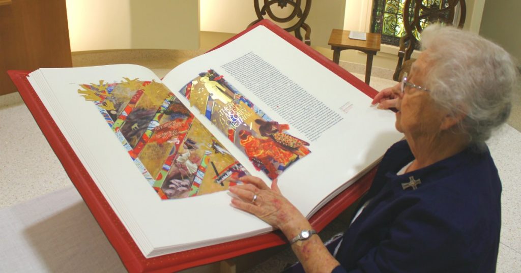 Sister Chab looks over the Heritage Edition of the Saint John’s Bible during its stay at Mercy Fort Smith in 2018.