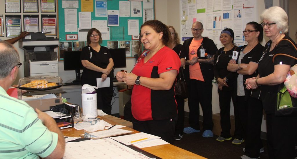 Sunny Anderson learns about her award from manager Brian Walker during a staff meeting.