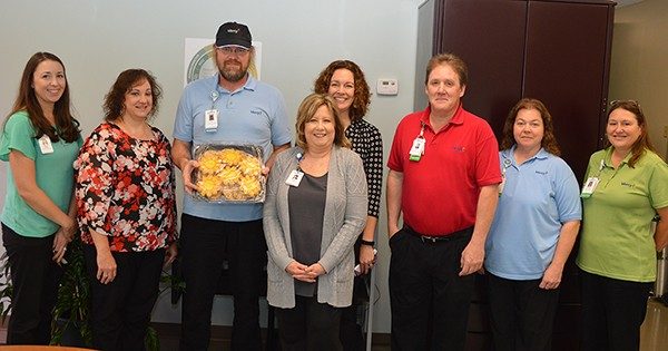 Tom Parr, holding the cookie tray, is surrounded by his co-workers at the presentation of the Sunshine Award.