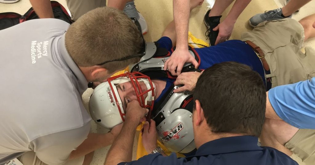 Mercy Sports Medicine athletic trainers practice removing the helmet from an injured football player. The helmet is unscrewed to avoid injuring the patient's spine.