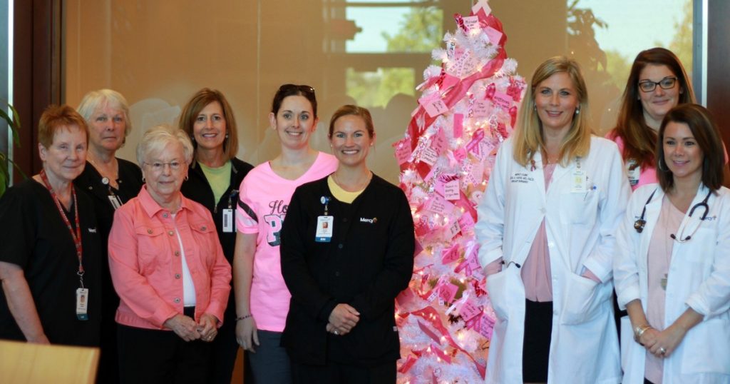 A group gathered to bless the Breast Cancer Tribute Tree.