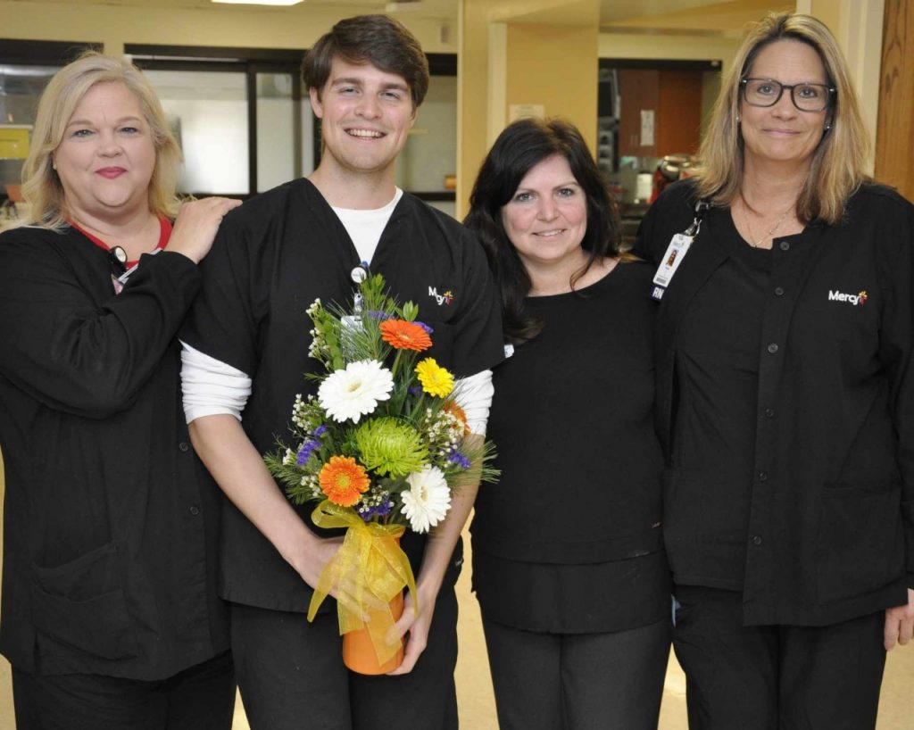 Chase Abeln, safety sitter, (holding flowers) celebrates his Daffodil Award with his mother, Tracy Abeln-Snyder (center); his aunt, Dawn Wotawa Bennett (left); and his aunt, Kelly Carson (right); who all work at Mercy Hospital South.