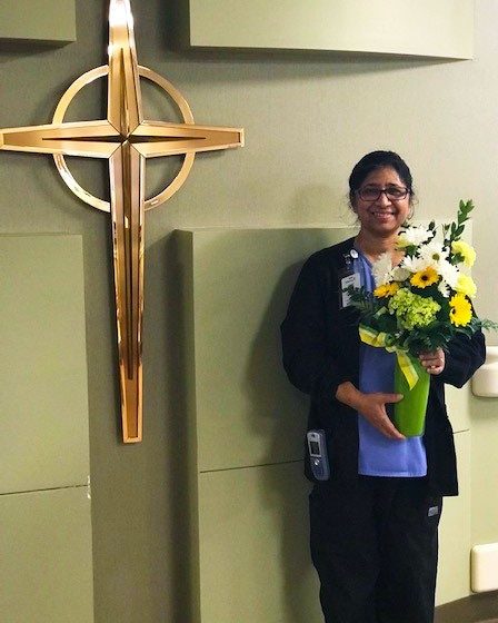 Marykutti Valiaparampil, RN, Float Pool, poses with the flowers presented to her for earning the monthly DAISY Award at Mercy Hospital South.