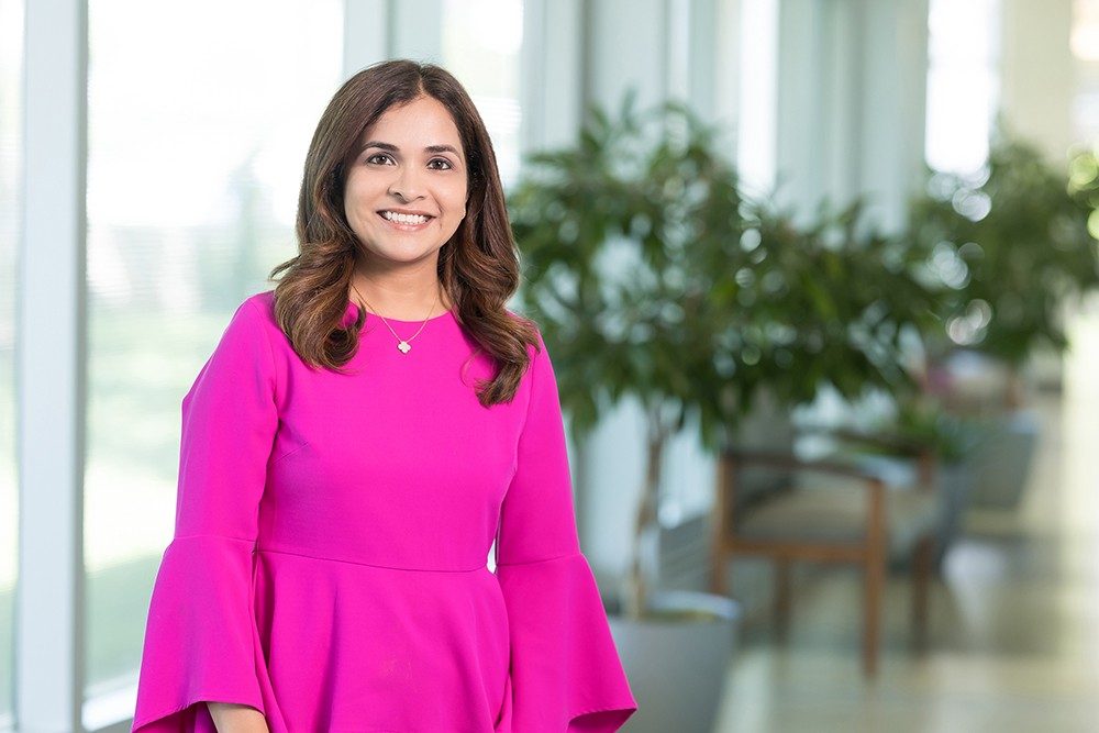 Dr. Manasi Hulyalkar poses with a smile in a pink dress