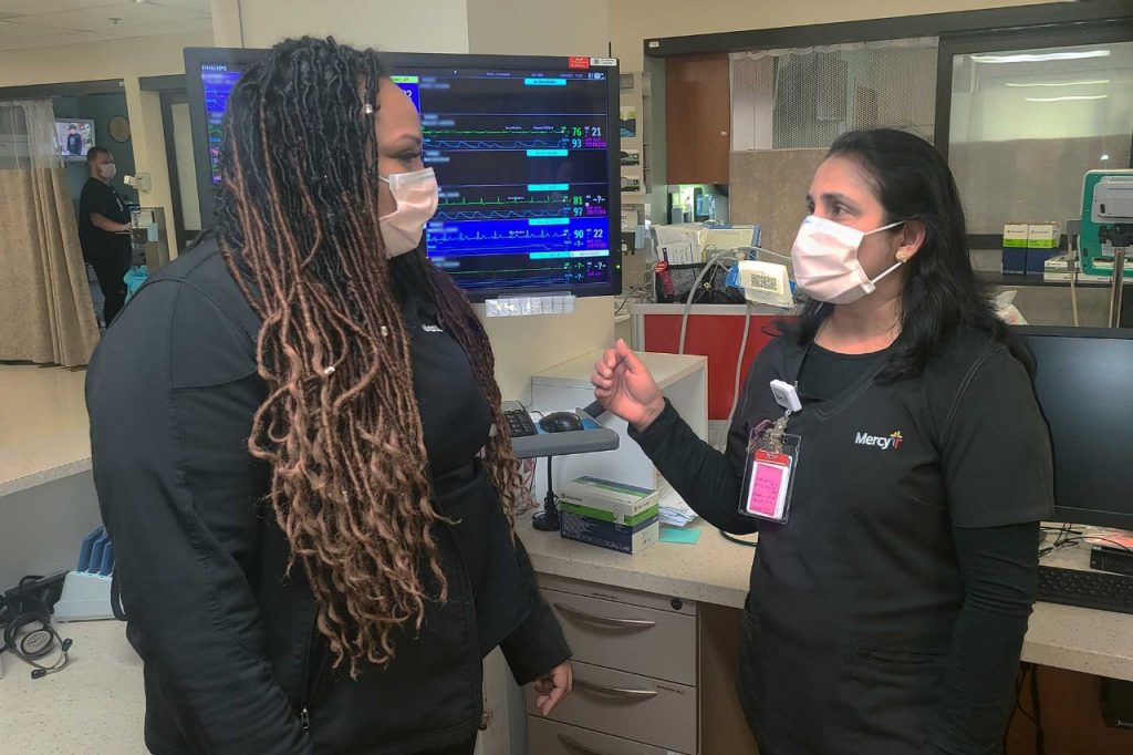 Mini Varghese, RN, speaks with a co-worker in the intensive care unit at Mercy Hospital South.