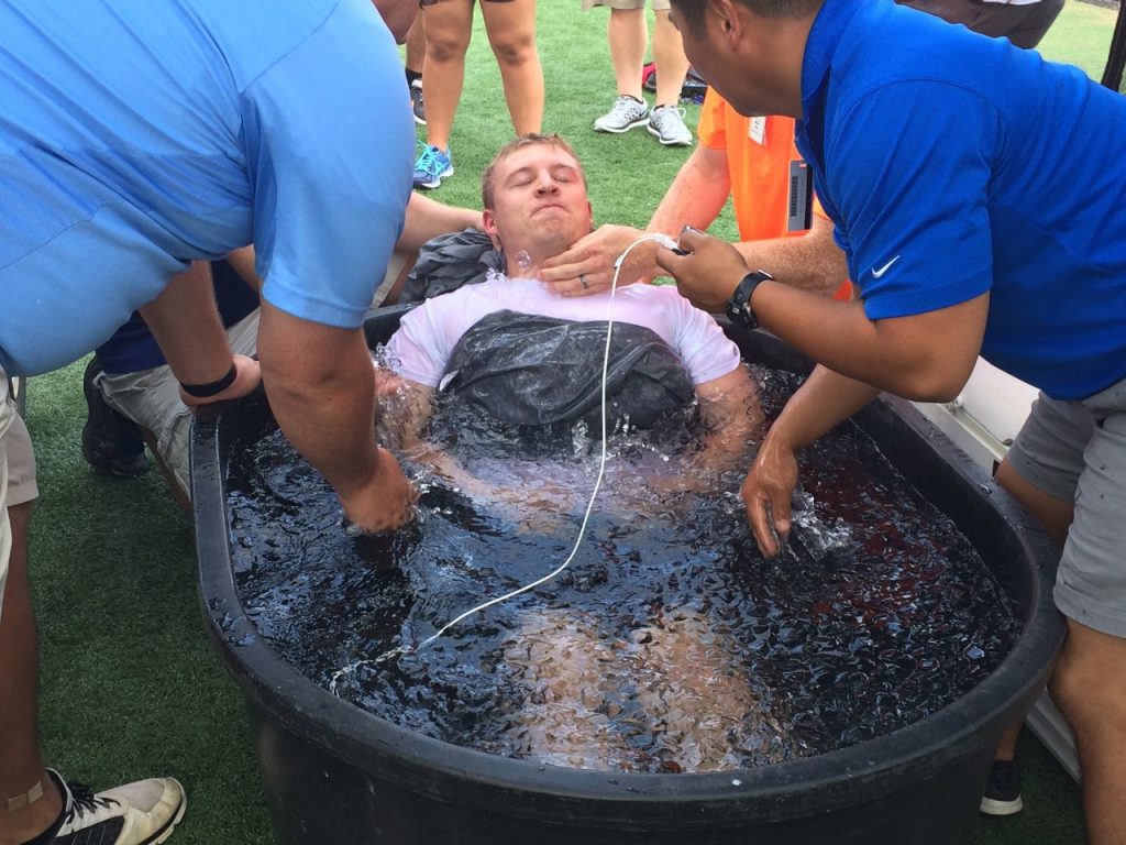Athletic trainers with Mercy Sports Medicine practice their response to a heat-related injury by dunking a fellow trainer into an ice bath.
