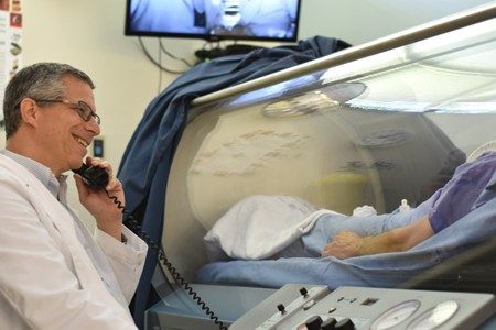Dr. David German talks with a patient in the hyperbaric chamber.
