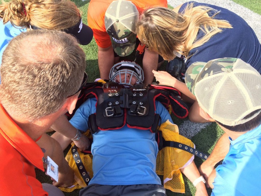 Athletic trainers with Mercy Sports Medicine practice how to take a helmet apart to help a player with possible head or neck trauma.
