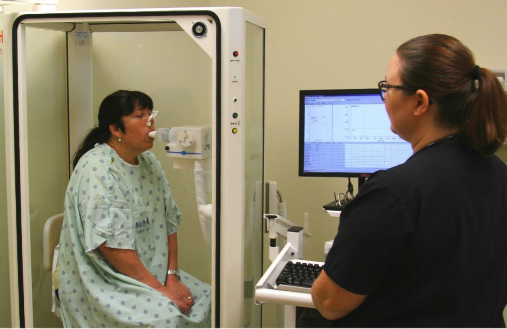 Sara Dobkins, a respiratory care practitioner, performs a pulmonary function test on a patient using a plethysmograph at Mercy Carthage.
