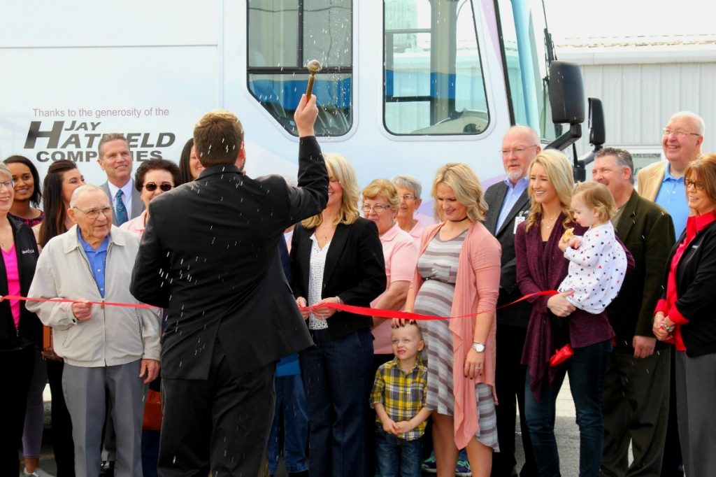 The Rev. Jeremy Huser of St. Rose Catholic Church blesses the Mercy mobile mammography van prior to a ribbon cutting Tuesday at Jay Hatfield Chevrolet Buick in Columbus. The Jay Hatfield Companies is donating $100,000 over five years to the Mercy Health Foundation to support the mobile mammography program and an upgrade of digital equipment.