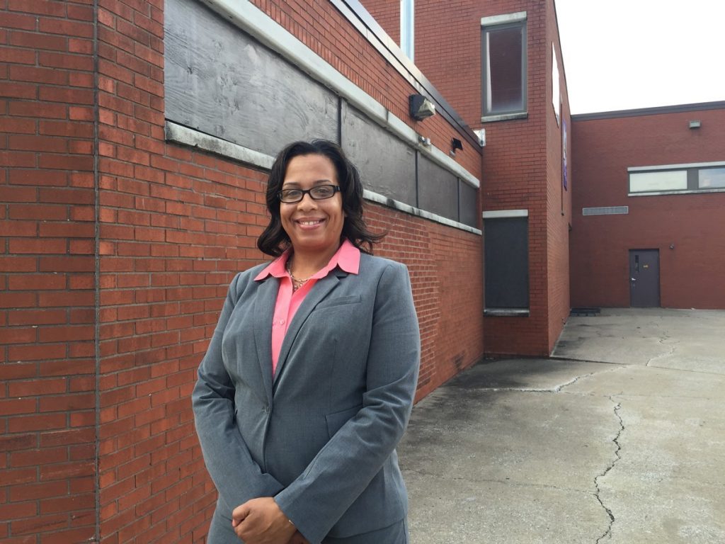 Theresa Densmore, MBA, stands in front of the now closed AM Jackson Elementary School in East St. Louis, Illinois, where she first discovered her love for numbers as a fourth-grade student who won a statewide mathematics competition.