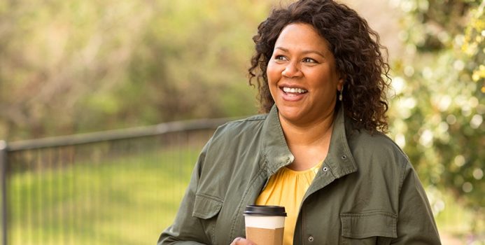 woman smiling with a cup of coffee