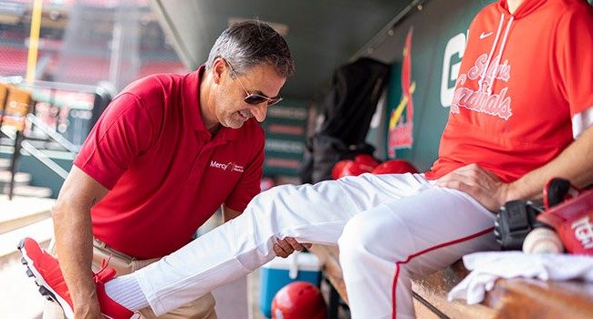 sports medicine employee working with a baseball player